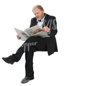 man in a suit sitting and reading a newspaper