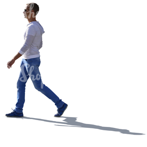 backlit young man in a white sweater walking