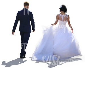 backlit bride and groom walking side by side