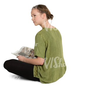 teenage girl sitting on a floor and reading a magazine