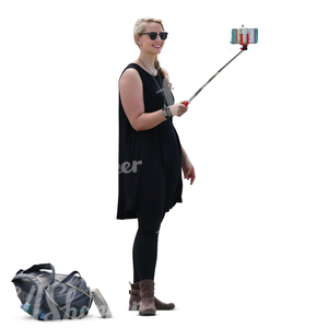 woman in a black dress standing and taking a selfie