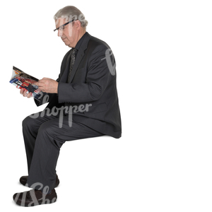 elderly man in a suit sitting and reading a newspaper