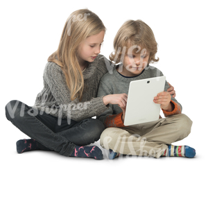 little boy and girl sitting on the floor and looking at ipad