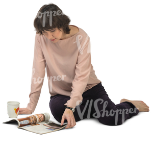 woman sitting on the floor and looking at a magazine