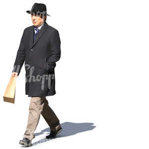 asian man in a black overcoat and hat walking in the sunlight