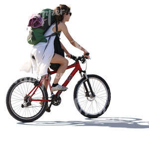 backlit woman with a backpack riding a bike