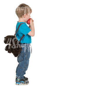 little boy standing and eating an apple