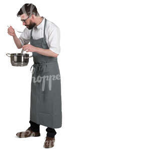 chef standing in the kitchen and tasting soup