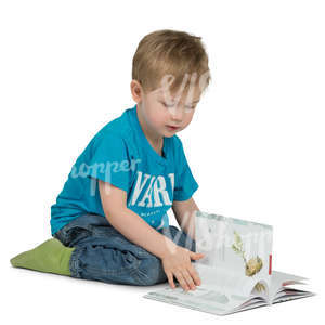 young boy sitting onn the floor and reading a book