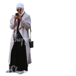 muslim woman standing and looking at her phone