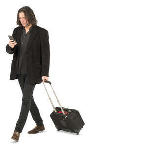 man with a suitcase walking and checking his phone