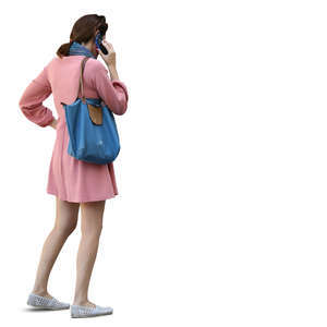 woman in a pink dress standing and talking on a phone