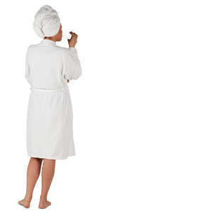 woman in a white bathrobe standing and drinking water