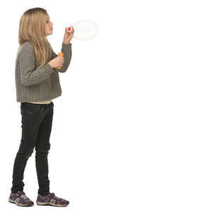 young girl standing and blowing soap bubbles