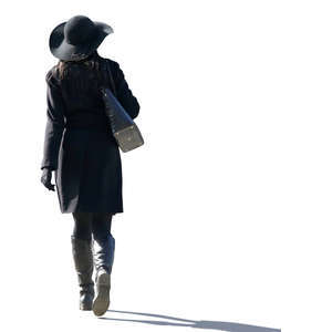 backlit woman with a black hat walking