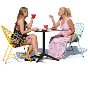 two women sitting in a cafe and eating cake