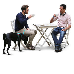 two men and a dog sitting in a cafe
