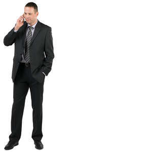 businessman in a suit standing and talking on the phone 