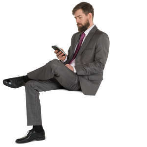 man in a fancy suit sitting and texting