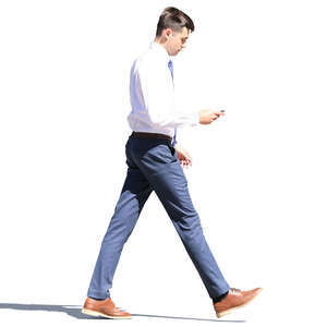 young businessman walking and looking at his phone