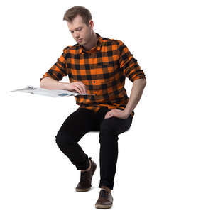 man sitting at a desk and reading a newspaper