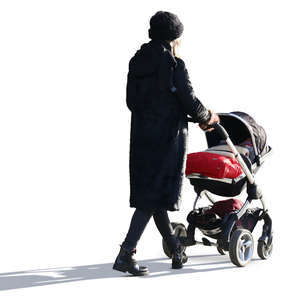 backlit woman in a black outfit walking with a baby carriage