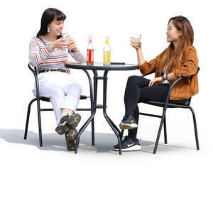 two women sitting and talking in a street cafe