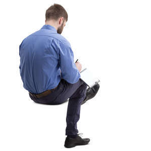 man sitting and taking notes