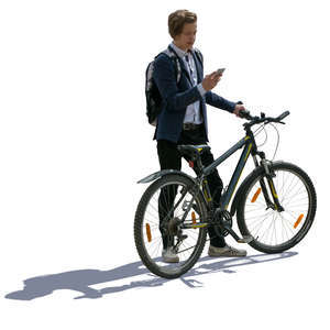 backlit teenage boy standing with a bike