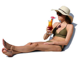 woman in a bikini sitting and drinking cocktail