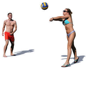 man and woman playing volleyball on the beach