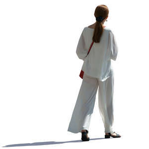 backlit woman in a white costume walking