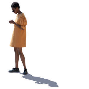 backlit african woman in a yellow dress standing