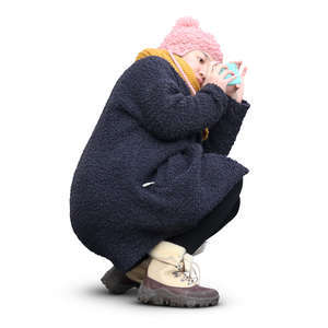 asian woman in winter coat squatting and taking a picture