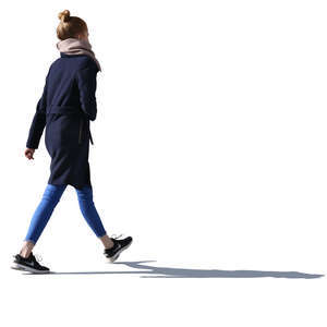 backlit young woman walking down the street