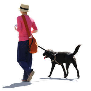 backlit woman walking with a black dog