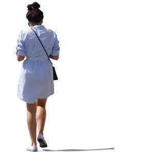 backlit woman on a dress walking on the street