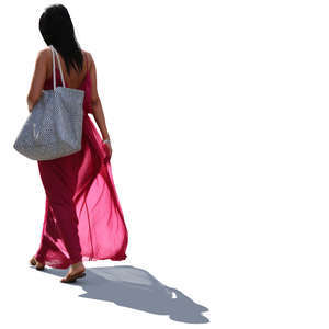 backlit woman in a long pink summer dress walking