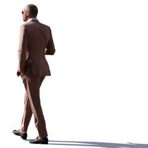 backlit man in a brown suit walking