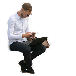 man with a laptop and phone sitting