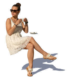 woman in a white summer dress sitting in a cafe