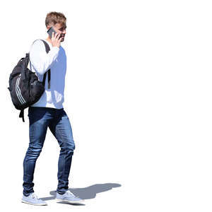 young man with a backpack walking and talking on the phone