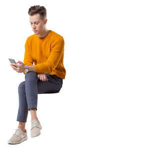 young man sitting and looking at his phone