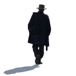 backlit man with a coat and hat walking