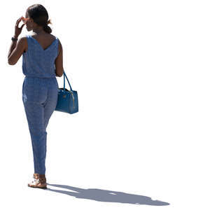 backlit woman in a blue jumpsuit standing