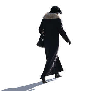 backlit woman in a winter coat walking