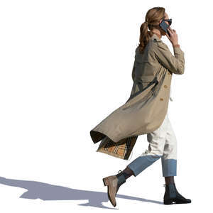 woman in a trenchcoat walking hastily