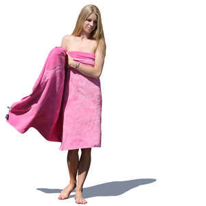 woman standing and wrapping a pink towel around herself