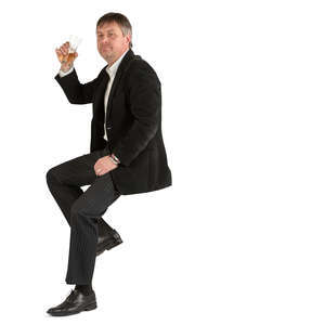 man in a suit sitting at a bar and drinking beer