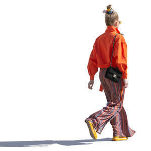 backlit woman in a colorful outfit walking
